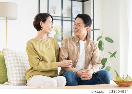 リビングでくつろぐミドルの夫婦 リビングでくつろぐミドルの夫婦 135904934