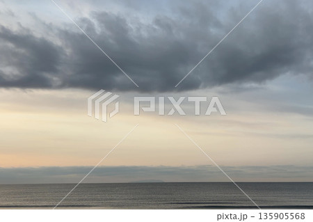 帯状の雲とやわらかな光が横から差し込んでいる早朝の空の景色 帯状の雲とやわらかな光が横から差し込んでいる早朝の空の景色 135905568