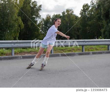 Caucasian woman rollerblading fast on road.  135906473