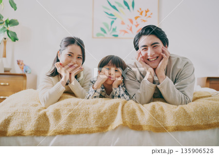 ベッドに寝転ぶファミリー 135906528