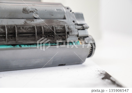 Broken laser printer cartridge on white background.  135906547