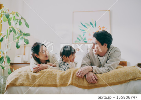 ベッドに寝転ぶファミリー 135906747