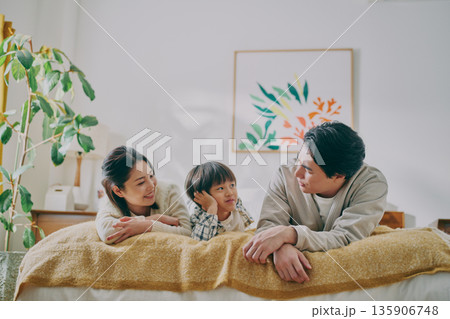 ベッドに寝転ぶファミリー 135906748