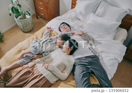 ベッドに寝転ぶファミリー 135906852
