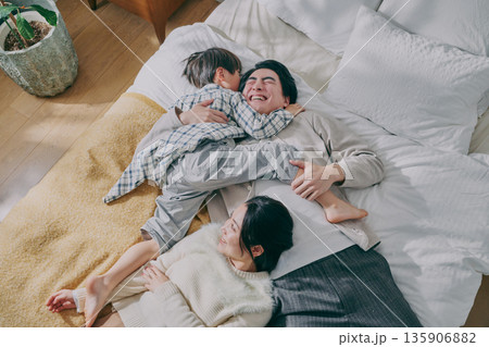 ベッドに寝転ぶファミリー 135906882