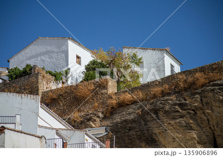 Unique whitewashed village built into dramatic rock formations, offers one of Andalusia most picturesque sights in Setenil de las Bodegas, Spain 135906896
