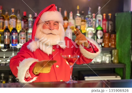 Santa Claus works at the bar making cocktails.  135906926
