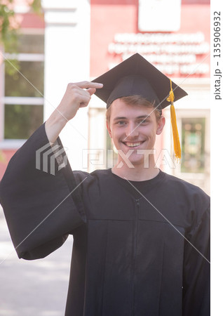 Caucasian young man in graduation gown communicating using sign language. Caucasian young man in graduation gown communicating using sign language. 135906932