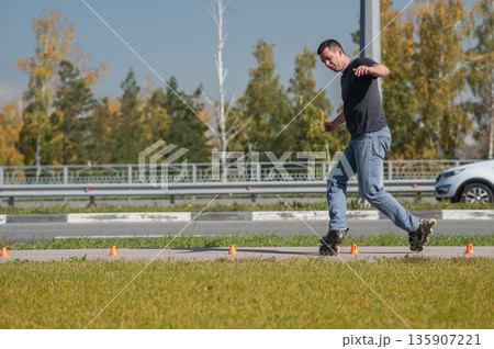 A Caucasian man rollerblades around the slalom course. A Caucasian man rollerblades around the slalom course. 135907221