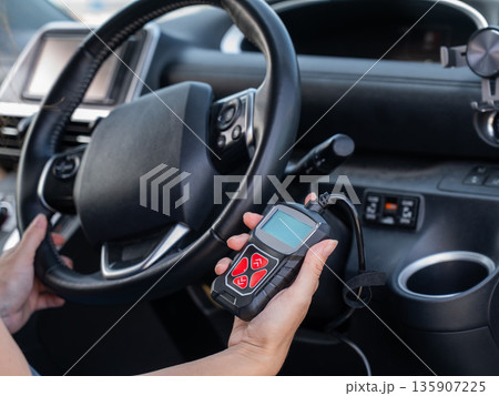 Woman using OBD2 diagnostic scanner.  135907225