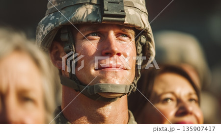 Soldier stands at attention during military ceremony with crowd watching in the background on a sunny afternoon 135907417