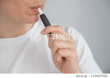 Woman smoking tobacco heating system. Electronic cigarette. Woman smoking tobacco heating system. Electronic cigarette. 135907509