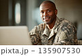 Soldier at a workstation smiling during a break at the military base in the afternoon 135907530