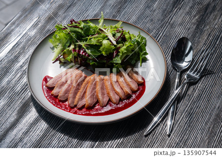 Roasted duck cut into pieces on a plate. Roasted duck cut into pieces on a plate. 135907544