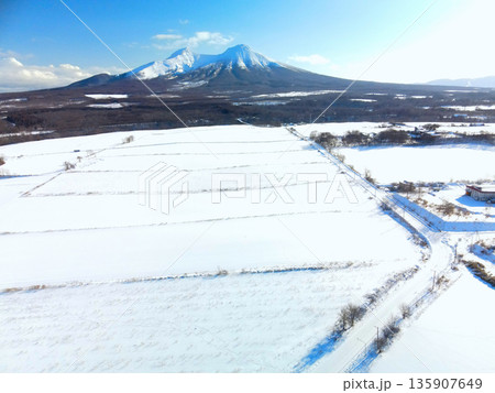 冬の北海道森町で雪原と駒ヶ岳の風景を空撮 135907649