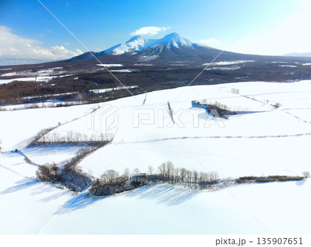 冬の北海道森町で雪原と駒ヶ岳の風景を空撮 冬の北海道森町で雪原と駒ヶ岳の風景を空撮 135907651