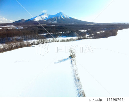 冬の北海道森町で雪原と駒ヶ岳の風景を空撮 135907654