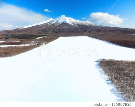 冬の北海道森町で雪原と駒ヶ岳の風景を空撮 135907656