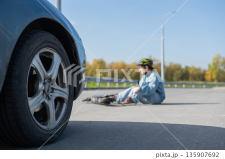 A Caucasian woman on a scooter after being hit by a car. 135907692