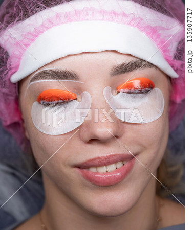 Caucasian woman undergoing eyelash lamination procedure. top view.  135907717