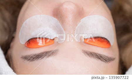 Caucasian woman undergoing eyelash lamination procedure. top view.  135907722