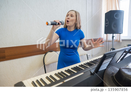 Caucasian woman singing into microphone. Caucasian woman singing into microphone. 135907856