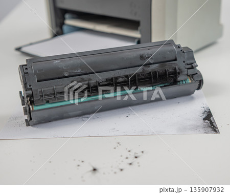 Broken laser printer cartridge on white background.  135907932