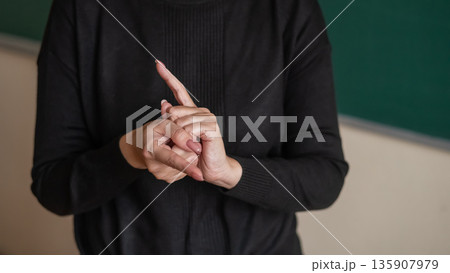 Woman showing the word translator in Russian sign language. Woman showing the word translator in Russian sign language. 135907979