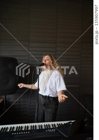 Caucasian woman singing into microphone in music studio. Caucasian woman singing into microphone in music studio. 135907997