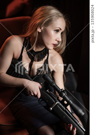 A Caucasian woman holds a rifle with a scope. A Caucasian woman holds a rifle with a scope. 135908024