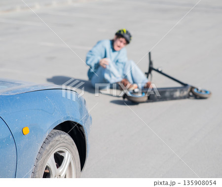 A Caucasian woman on a scooter after being hit by a car. A Caucasian woman on a scooter after being hit by a car. 135908054