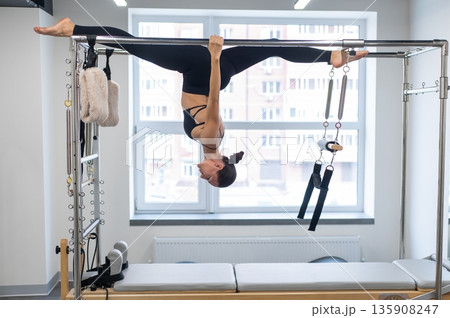 Caucasian woman doing pilates on reformer.  135908247