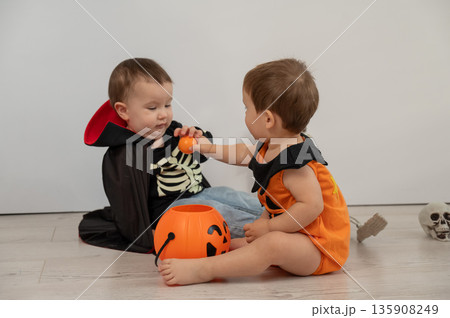Cute kids celebrate halloween on white background. Two little boys in dracula costume and pumpkin. Cute kids celebrate halloween on white background. Two little boys in dracula costume and pumpkin. 135908249
