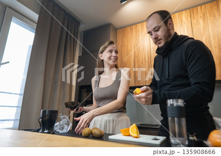 A Caucasian couple prepares freshly squeezed juice. 135908666