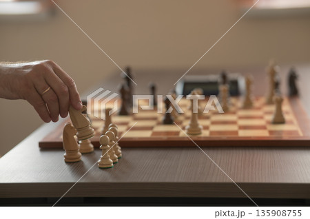 Close up of hands of middle aged caucasian man playing chess.  135908755