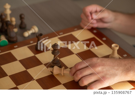 Close up of hands of middle aged caucasian man playing chess. Close up of hands of middle aged caucasian man playing chess. 135908767