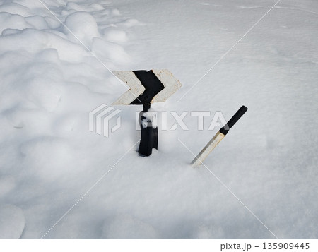 Vintage Railroad Switch Lever in Snow. Old manual railway switch stand lever with black and white striped target stuck in deep fresh snow outdoors. Vintage Railroad Switch Lever in Snow. Old manual railway switch stand lever with black and white striped target stuck in deep fresh snow outdoors. 135909445