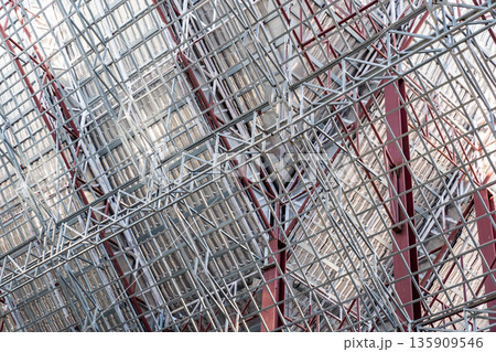 Uprisen angle photo shot of the huge steel roof frame structure detail under construction at the work site. 135909546