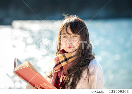 海辺で本を読む女性 135909868