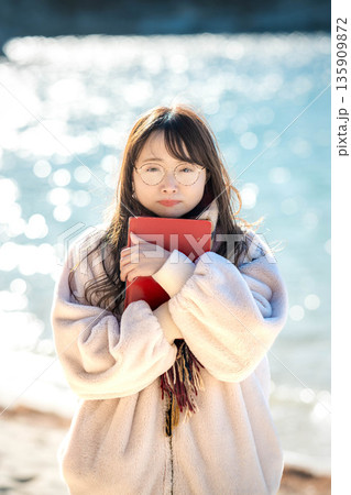 海辺で本を読む女性 135909872