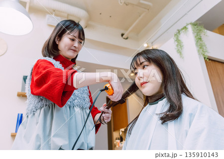 美容院でヘアセットしてもらう女性 若い美容師 美容院でヘアセットしてもらう女性 若い美容師 135910143