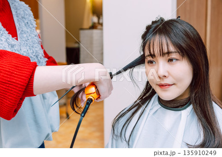 美容院でヘアセットしてもらう女性 若い美容師 美容院でヘアセットしてもらう女性 若い美容師 135910249