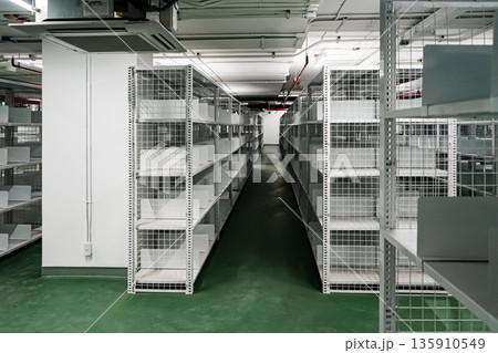 White shelves are lined up all over the area in a warehouse with a green floor. It also has an excellent security system. White shelves are lined up all over the area in a warehouse with a green floor. It also has an excellent security system. 135910549