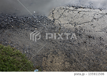 Rain Puddles On Concrete Ground, A moody photo of rain puddles on concrete shallow water reflecting gray sky with ripples spreading, perfect for urban weather or quiet aftermath documentary. Rain Puddles On Concrete Ground, A moody photo of rain puddles on concrete shallow water reflecting gray sky with ripples spreading, perfect for urban weather or quiet aftermath documentary. 135911506