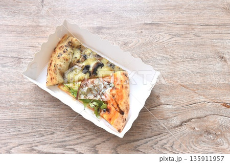 piece of baking homemade parma ham and truffle mushroom pizza in paper tray on table 135911957