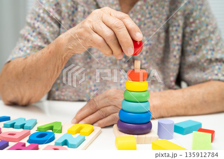 Asian elderly woman playing game. 135912784
