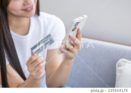 スマホとクレジットカードを持つ若い女性 スマホとクレジットカードを持つ若い女性 135914174