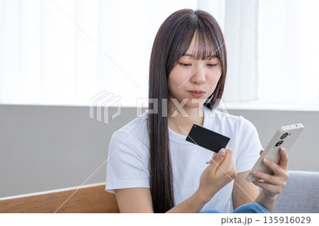 スマホとクレジットカードを持つ若い女性 スマホとクレジットカードを持つ若い女性 135916029