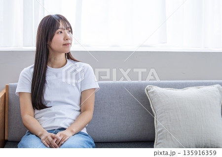 ソファーでリラックスする若い女性 ソファーでリラックスする若い女性 135916359