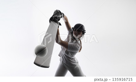 Cricket player hitting ball with bat during powerful shot in studio. Cricket player hitting ball with bat during powerful shot in studio. 135916715